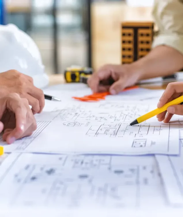 Image of team engineer checks construction blueprints on new project with engineering tools at desk in office.