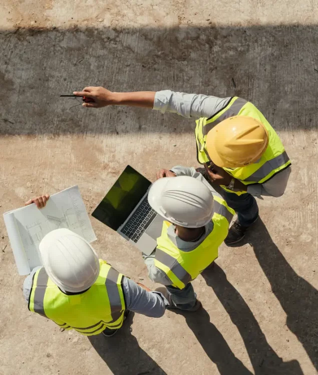 Top view, Team engineer building inspection use tablet computer and blueprint working at construction site. Civil Engineer, Contractor and Architect discussing in construction site.